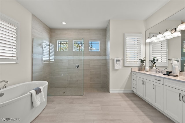 bathroom with plus walk in shower, vanity, and plenty of natural light