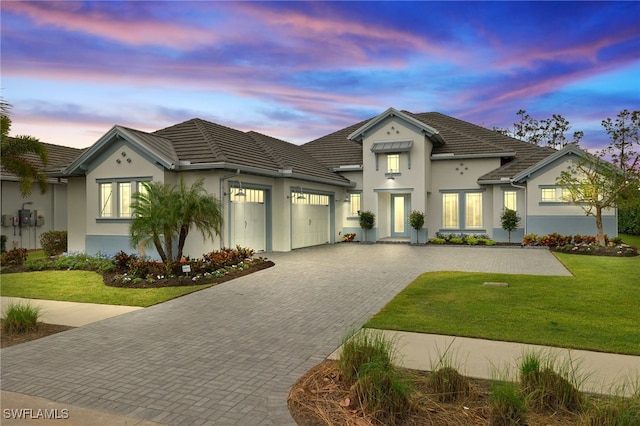 view of front of property featuring a garage and a lawn