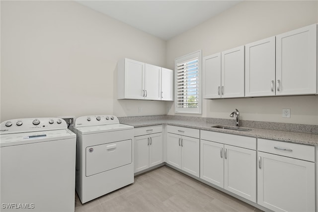 laundry area with cabinets, sink, and washer and dryer