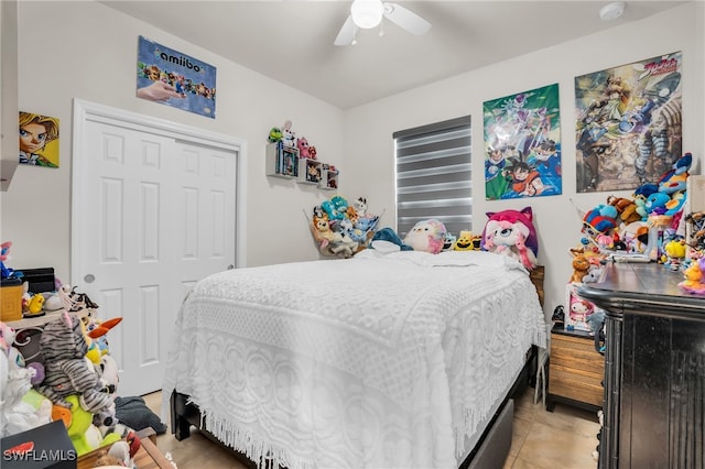 tiled bedroom featuring ceiling fan and a closet