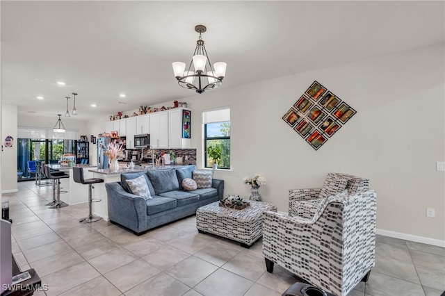 tiled living room featuring an inviting chandelier and a healthy amount of sunlight