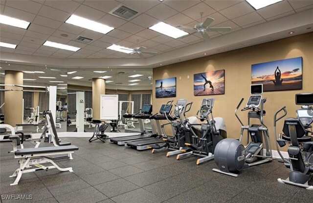 exercise room with ceiling fan and a drop ceiling