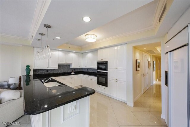 7575 Pelican Bay Blvd Unit 403, Naples, FL 34108 - kitchen featuring white cabinets, a tray ceiling, ornamental molding, a sink, and a peninsula