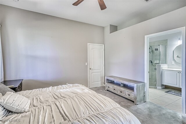 bedroom with ceiling fan, light tile patterned floors, and ensuite bathroom