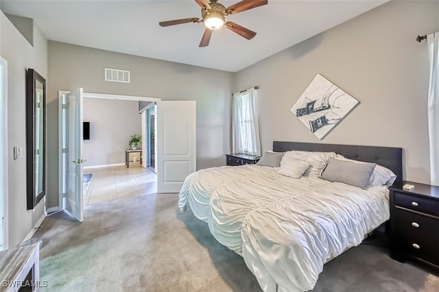 carpeted bedroom with baseboards, visible vents, and a ceiling fan