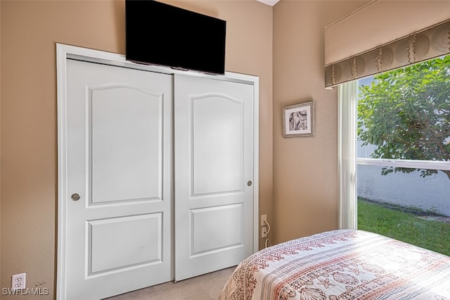 bedroom with light colored carpet and a closet