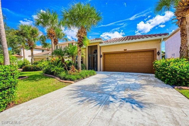 mediterranean / spanish-style house with a tile roof, driveway, an attached garage, and stucco siding