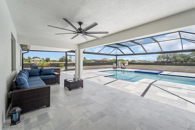 view of pool with an outdoor living space, a lanai, a patio area, and ceiling fan