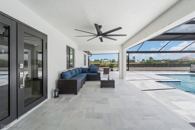 view of patio / terrace featuring glass enclosure, a fenced in pool, ceiling fan, and outdoor lounge area