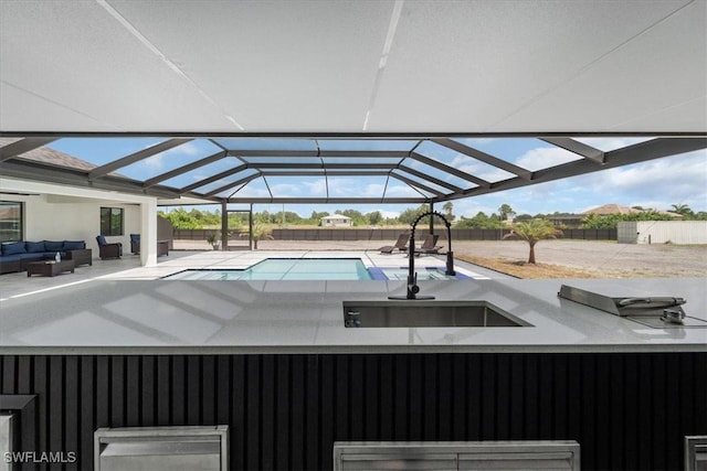 view of pool featuring glass enclosure, a patio, and an outdoor hangout area