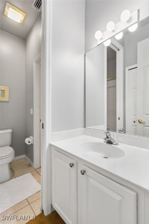 bathroom featuring vanity, tile patterned floors, and toilet