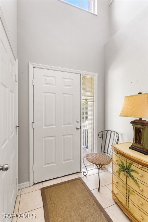 entryway with light tile patterned floors and a high ceiling