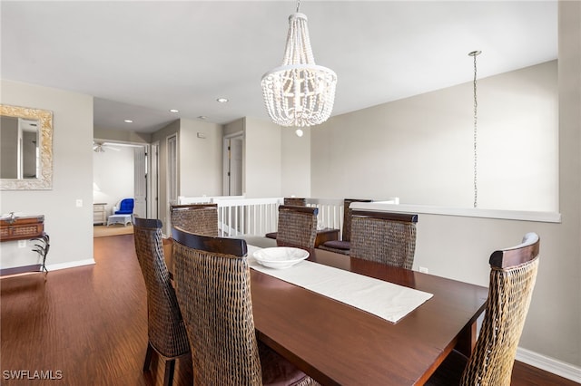 dining area featuring dark hardwood / wood-style floors and ceiling fan with notable chandelier