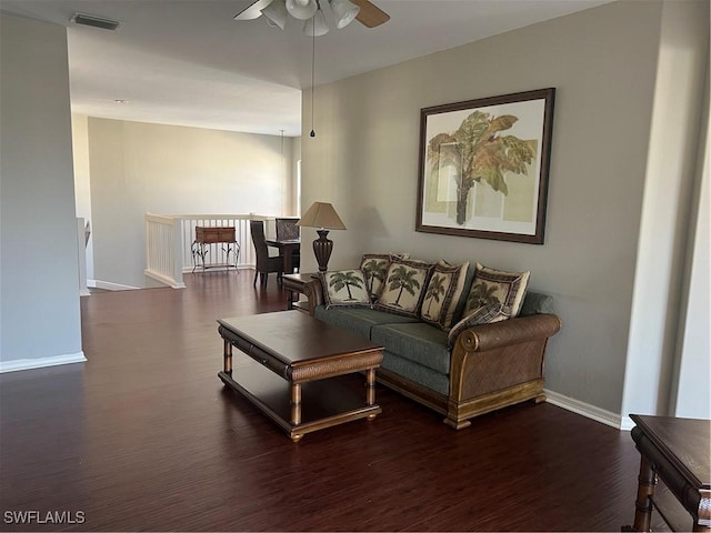 living room featuring ceiling fan and dark hardwood / wood-style flooring