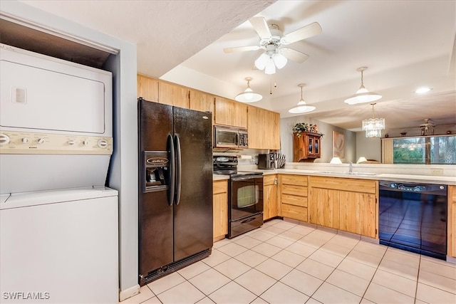 kitchen featuring hanging light fixtures, black appliances, sink, ceiling fan with notable chandelier, and stacked washer / dryer