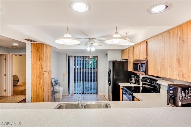 kitchen featuring black appliances, sink, hanging light fixtures, light tile patterned floors, and light brown cabinets