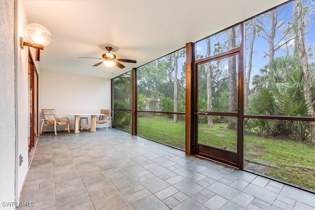 unfurnished sunroom with ceiling fan