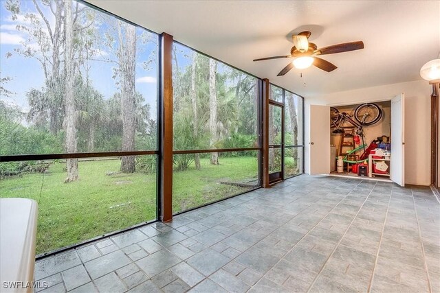 unfurnished sunroom with ceiling fan