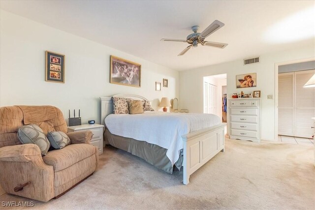 bedroom with light carpet, a closet, and ceiling fan