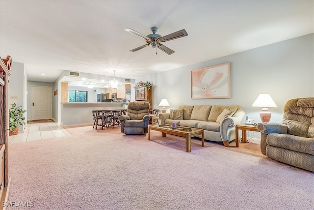 living room with light carpet and ceiling fan with notable chandelier