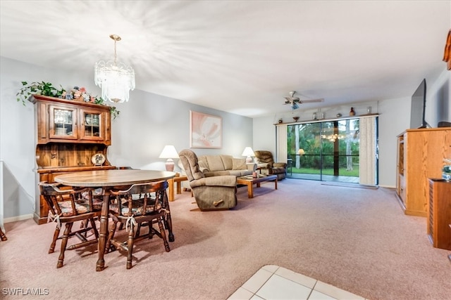 carpeted dining space with ceiling fan with notable chandelier