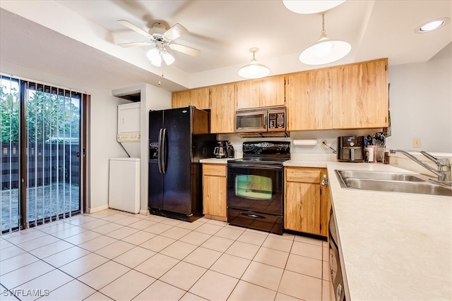 kitchen featuring stacked washer and dryer, sink, black appliances, decorative light fixtures, and ceiling fan