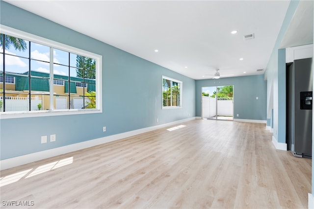 unfurnished living room with light wood-type flooring and ceiling fan