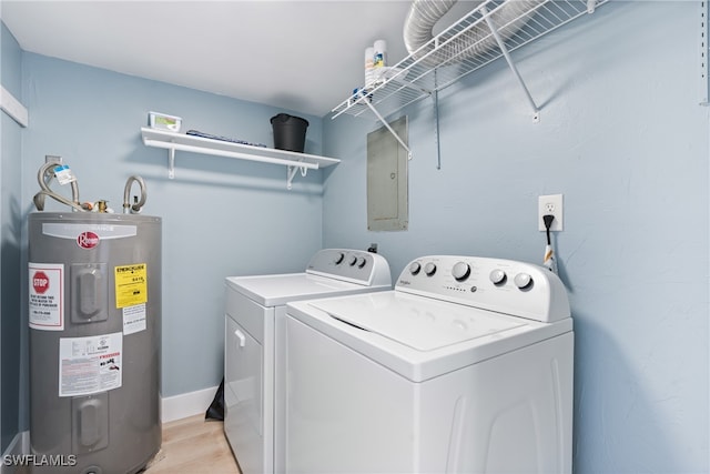 laundry area with water heater, electric panel, washing machine and clothes dryer, and light hardwood / wood-style flooring