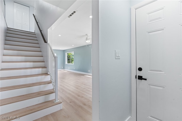 stairway featuring wood-type flooring and ceiling fan