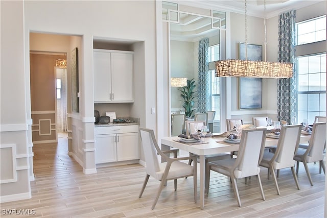 dining area featuring crown molding, a towering ceiling, and light hardwood / wood-style floors