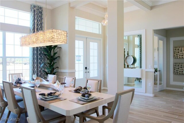 dining area featuring light wood-type flooring, ornamental molding, and french doors