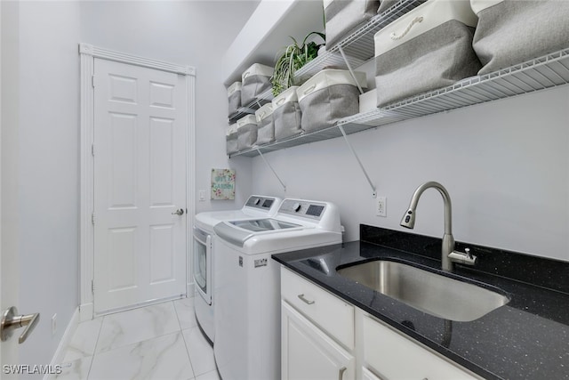 laundry room with cabinets, washing machine and dryer, and sink