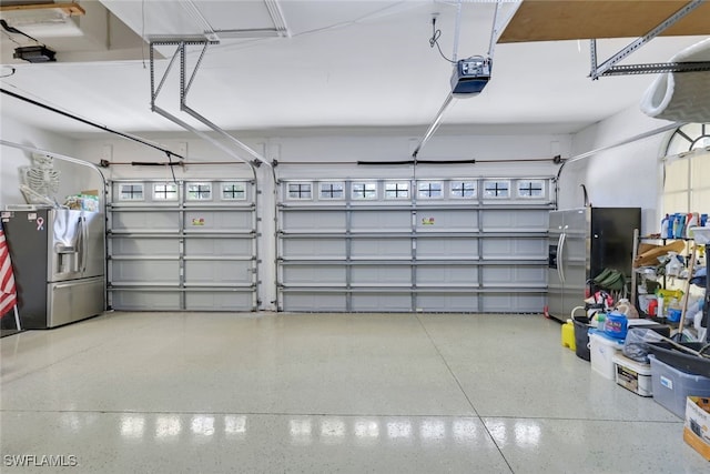 garage featuring a garage door opener and stainless steel fridge with ice dispenser