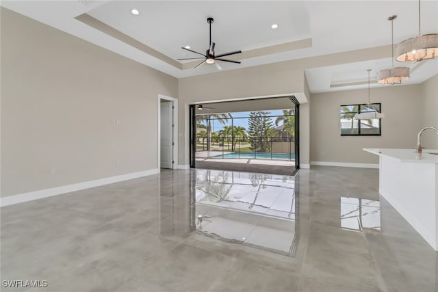 foyer entrance featuring ceiling fan, sink, and a raised ceiling