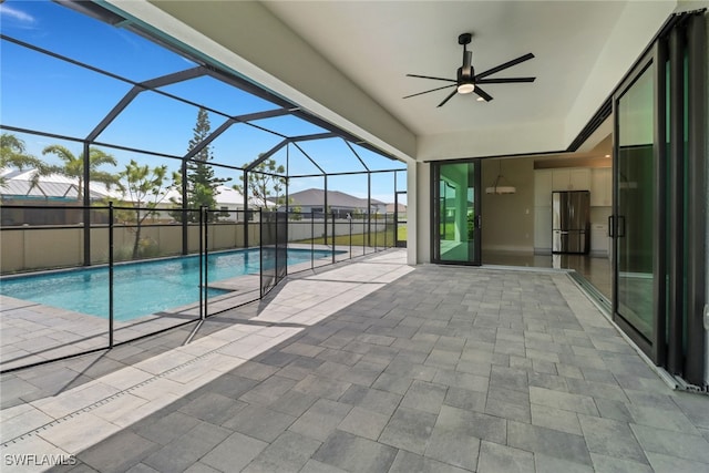 view of swimming pool featuring a patio, glass enclosure, and ceiling fan