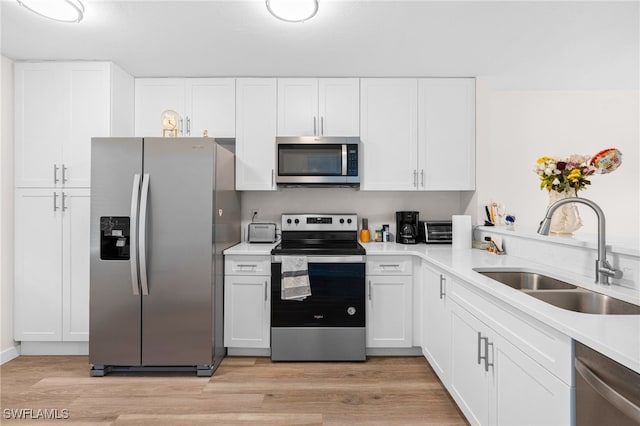 kitchen featuring light hardwood / wood-style flooring, sink, appliances with stainless steel finishes, and white cabinetry