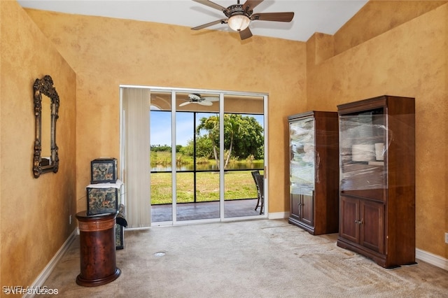 unfurnished living room featuring light carpet, high vaulted ceiling, and ceiling fan