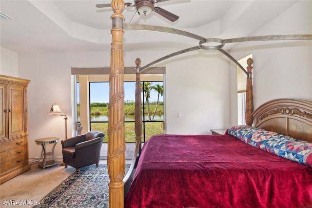 bedroom featuring a raised ceiling, access to exterior, ceiling fan, and carpet flooring