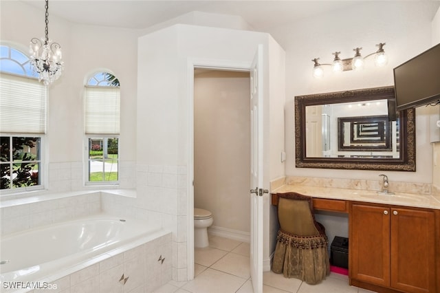 bathroom with vanity, an inviting chandelier, tile patterned flooring, toilet, and tiled tub