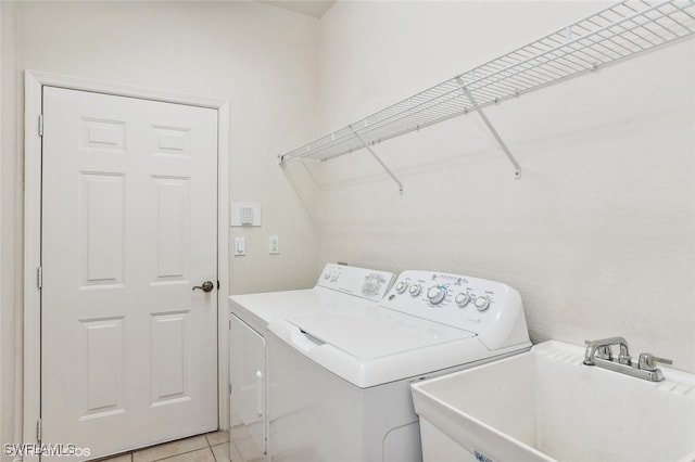 washroom with washing machine and clothes dryer, sink, and light tile patterned floors