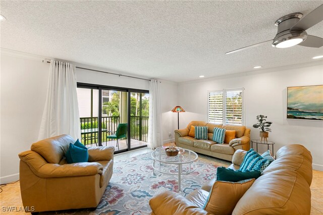 living room featuring ceiling fan, light tile patterned floors, a textured ceiling, and ornamental molding