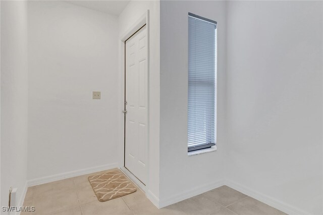 doorway to outside with light tile patterned floors