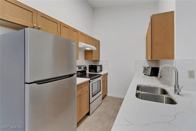 kitchen with light tile patterned floors, light stone countertops, stainless steel appliances, sink, and decorative backsplash