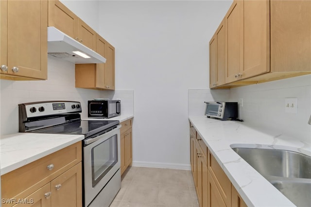 kitchen featuring light tile patterned floors, stainless steel range with electric cooktop, light stone counters, and sink