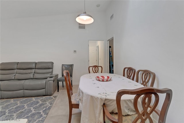 tiled dining area featuring a high ceiling