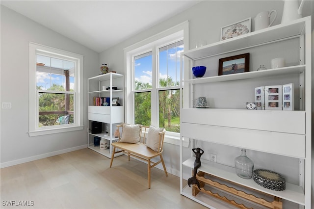 sitting room featuring plenty of natural light, baseboards, vaulted ceiling, and wood finished floors