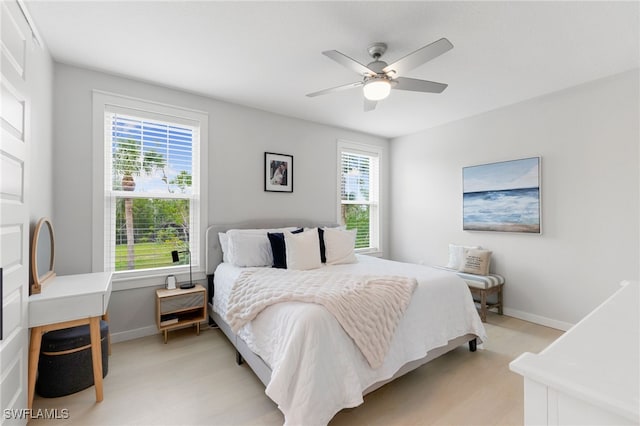 bedroom featuring baseboards, ceiling fan, and light wood-style floors
