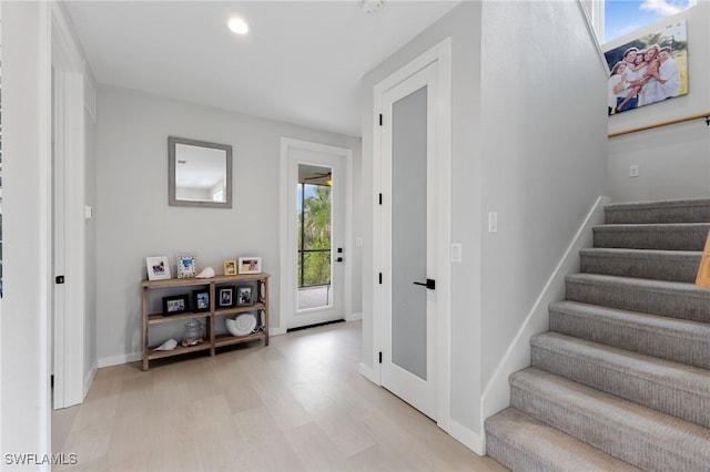 stairs featuring baseboards, wood finished floors, and recessed lighting