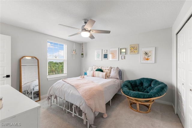 bedroom featuring light carpet, a closet, and a textured ceiling