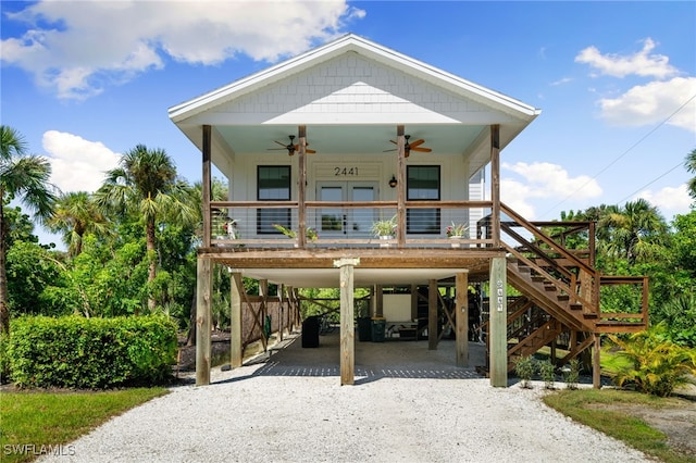 raised beach house featuring ceiling fan, covered porch, and a carport